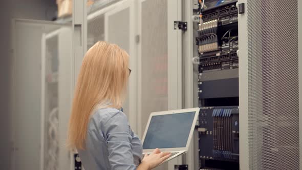 Woman Blockchain Diagnostic Network Engineer In Server Room Mining Farm. Specialist On Server Racks