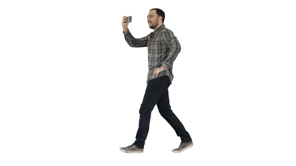 Young man taking photo with smartphone while walking on