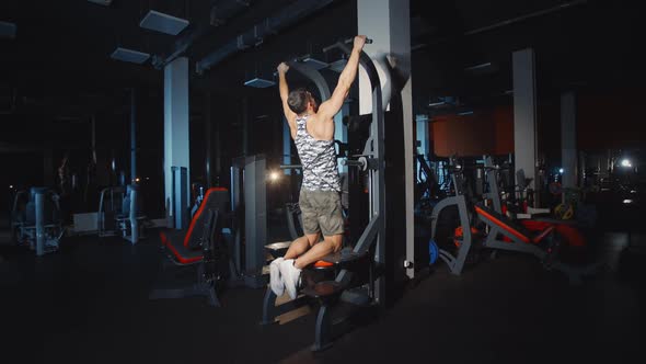 Athlete Doing Workout Pull Up Training Hands And Shoulders on Weights Lifting Exercise Machine Gym
