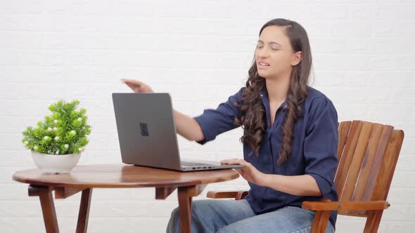 Frustrated Indian girl working on a laptop
