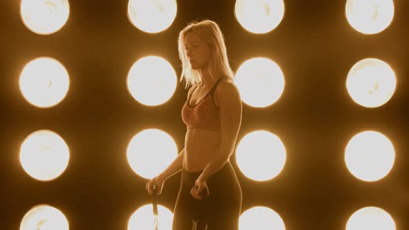 Beautiful Woman Working Out In Front Of A Wall Of Lights