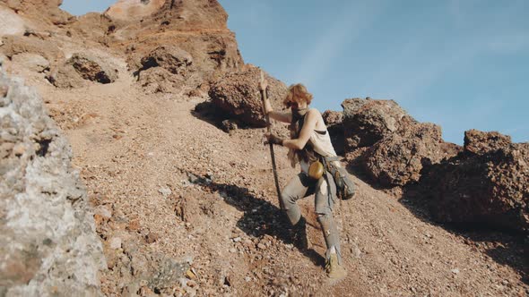 Woman Walking Down Steep Scree in Dystopian World