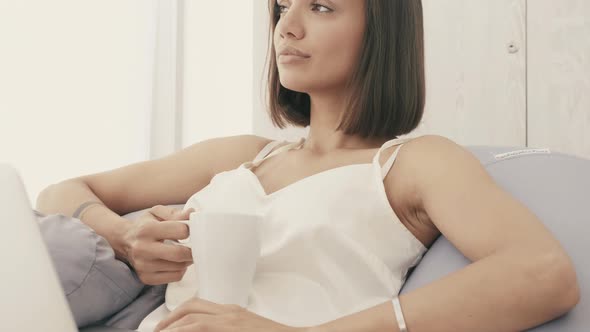 Carefree model sitting on soft bag chair and using laptop