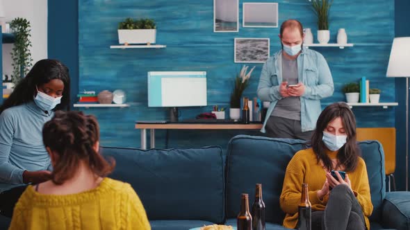 Group of Diverse Friends with Face Masks Actively Using Phones