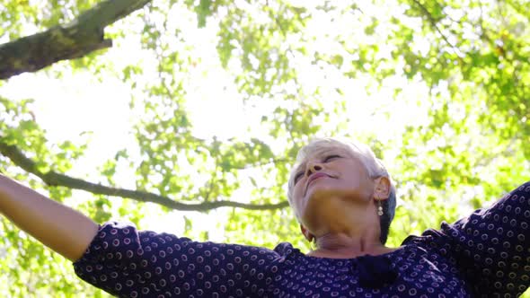 Senior woman standing with her arms wide open