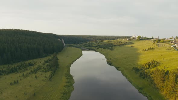 Aerial View of the River with a Rock and Forest on the Banks