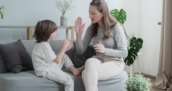 Female Parent Playing with Male Kid Clapping Hands at Home