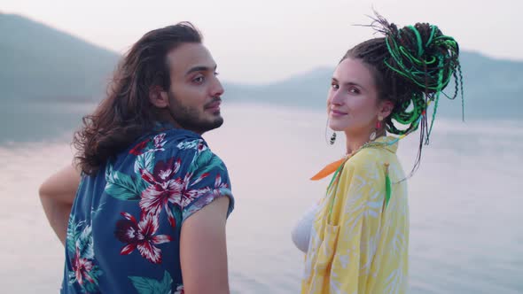 Portrait of Happy Multiethnic Couple Sitting on Lake Pier