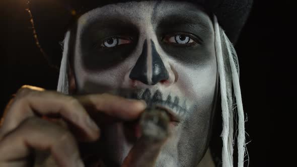 Close-up Shot of Sinister Man Face with Halloween Skeleton Makeup Smoking Cigar, Making Faces