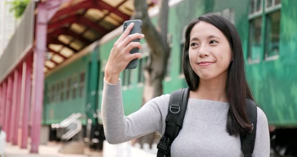 Woman traveler using smart phone for taking photo and video 