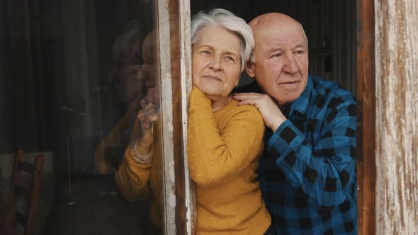 Mature Caucasian Married Couple Watching Through the Window Then Look at Each Other Copy Space