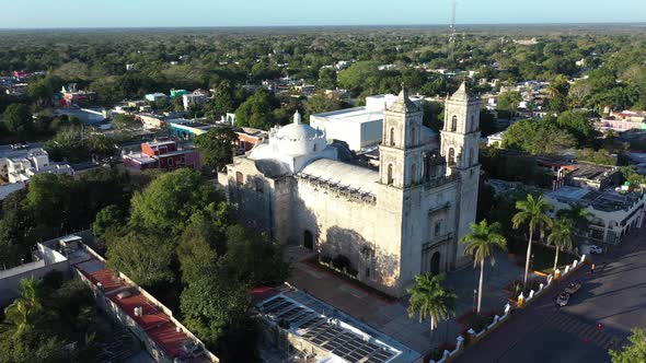 Aerial trucking shot to left showing Cathedral de San Gervasio and the city beyond after sunrise in