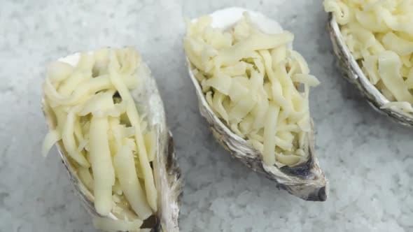 Motion Above Oysters with Sauce and Grated Cheese on Table