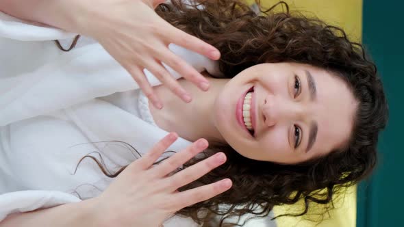 Curly Haired Girl Looking at Camera with Charming Smile Laughing