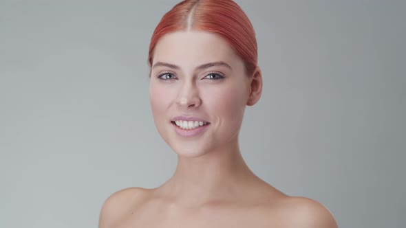 Studio portrait of young, beautiful and natural redhead woman. Beauty concept.