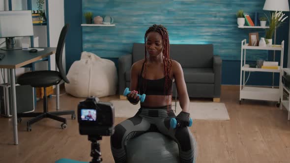 Black Woman Trainer Practicing Morning Yoga Exercise Sitting on Fitness Swiss Ball