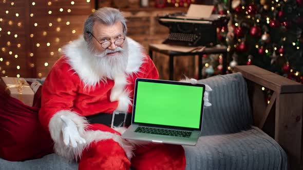 Friendly Male Santa Claus Holding Laptop Green Screen Attracts Attention