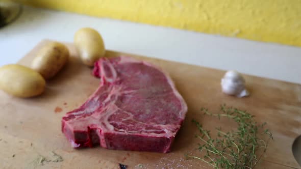 Camera Tilt and focus in over steak on wooden cutting board with garnish