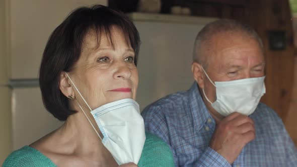 Old Couple Behind Window Take Off Masks