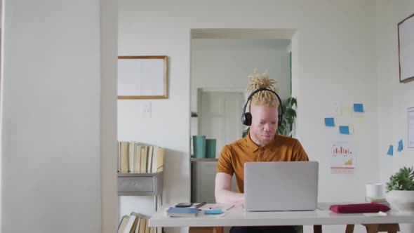 Albino african american man with dreadlocks making video call on the laptop