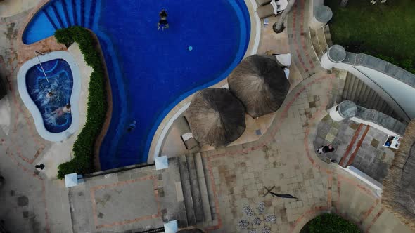 Aerial Drone View of Swimming Pool with Beach Umbrellas Beds with Hotel at Cancun Mexico