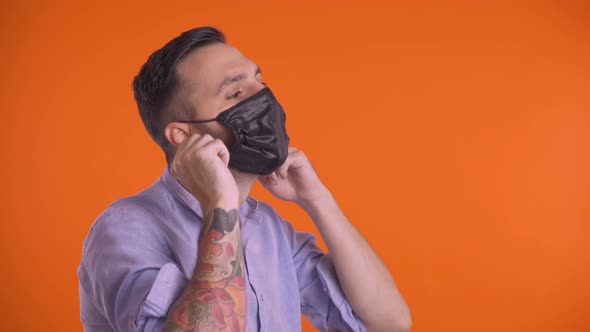 Profile Shot of Young Man Taking Off Face Mask and Breathing Freely. Smiling at Camera Happy