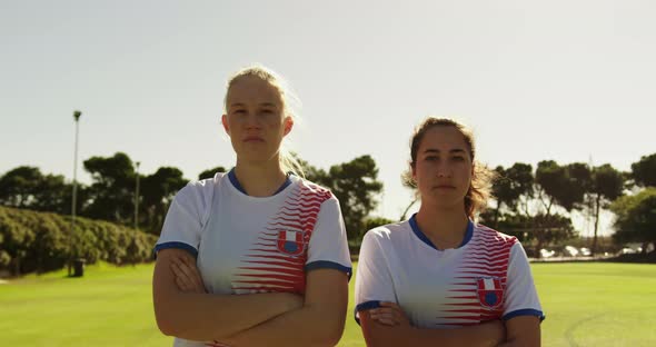 Female soccer players standing with arms crossed on soccer field. 4k