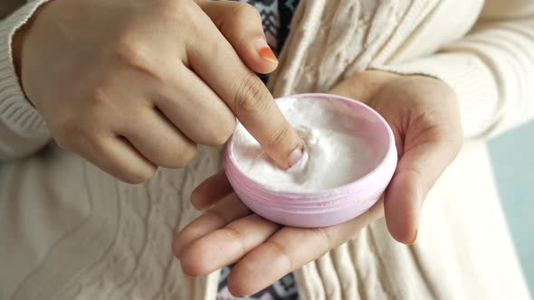 Woman Applying Beauty Cream Onto Skin at Home Top View