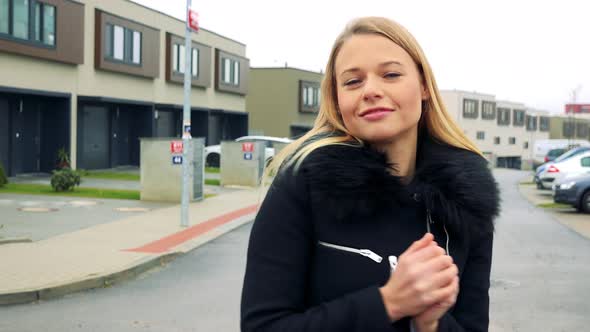 A Young, Attractive Woman Dances on the Street in a Suburban Area