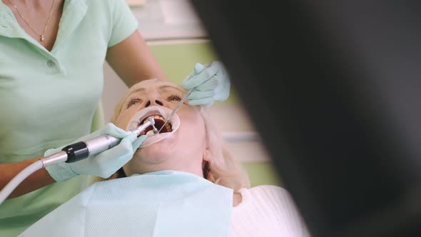 Female Dentist Examining Elderly Woman s Teeth in the Office