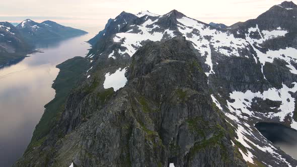 Drone footage of the amazing mountains and fjords of Kvaløya in northern Norway late at night during