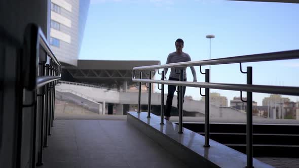 Young caucasian male perfoming parkour exercises using railings.