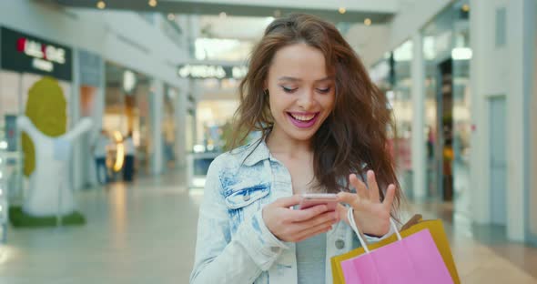 A Smiling Woman is Texting on the Phone