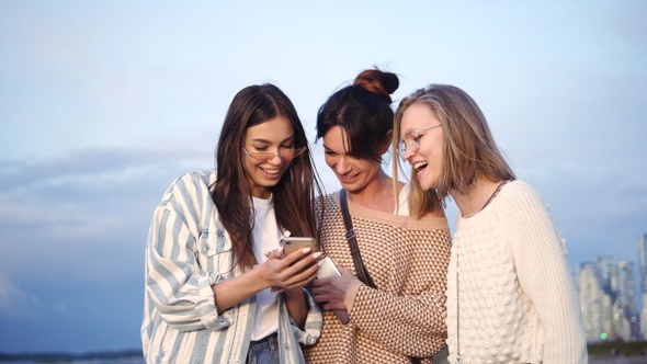 Girls Amused By Something They See On A Cell Phone.