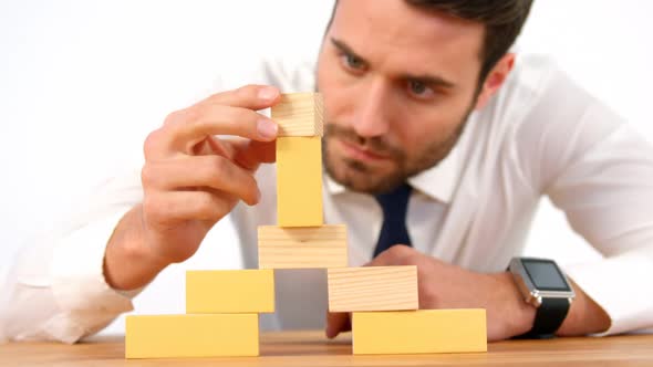 Businessman playing with building blocks
