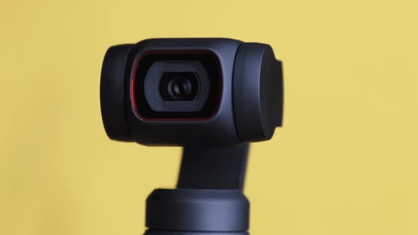 Mechanical Gimbal Camera Lens Rotates on Yellow Background Robotic Camera Macro