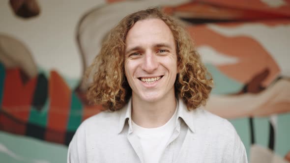 Cheerful curly-haired man looking at the camera