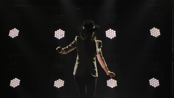 Silhouette of Stylish Sexy Woman Dancing Elements of Flamenco in Dark Smoky Studio Against Backdrop