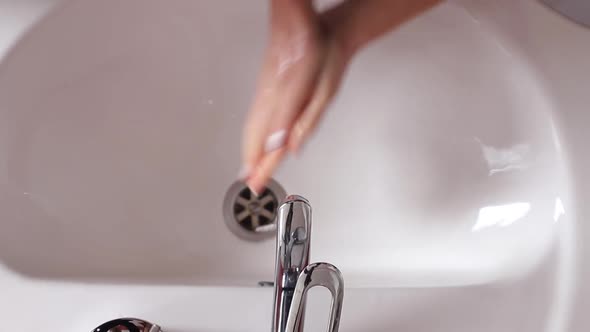 Woman Washes Her Hands in the Bathroom with Water Soap and Foam