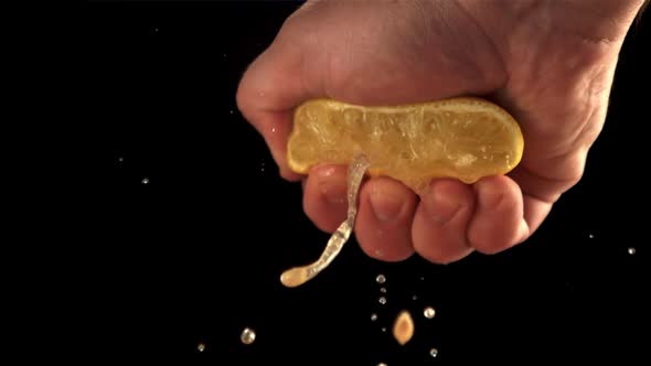 Super Slow Motion Lemon Juice Squeezes Out of Fresh Lemon the Male Hand