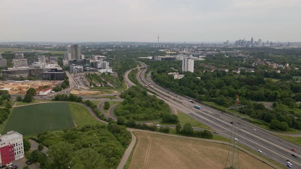 Urban highway in Germany leading toward a large city in the distance. Slow aerial zoom