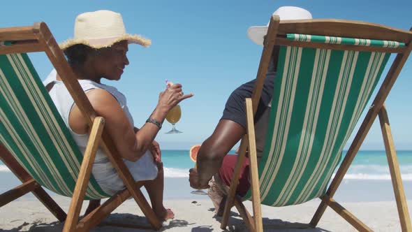 Senior couple on deck chairs with cocktails