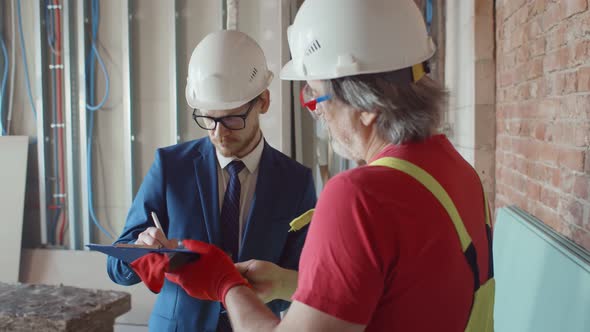 Contractor Signing Document for Foreman on Construction Site alt