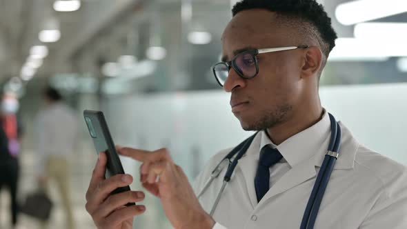 Portrait of Attractive Male African Doctor Using Smartphone 