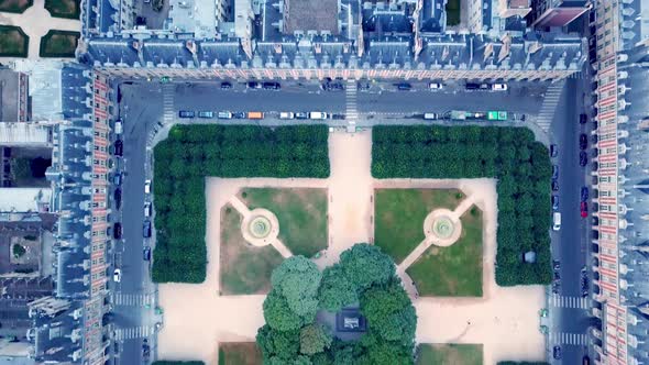 Panning drone view of Place des Vosges. Symmetrical square surrounded by road and houses from above,