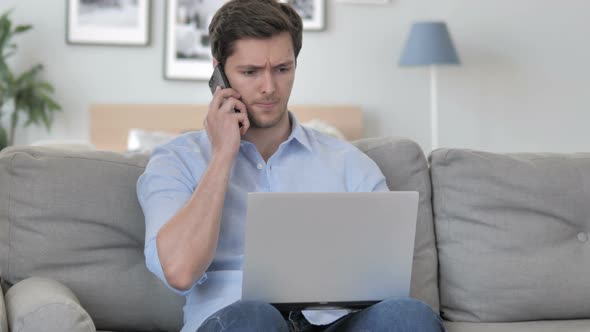 Handsome Young Man Discussing Work on Phone