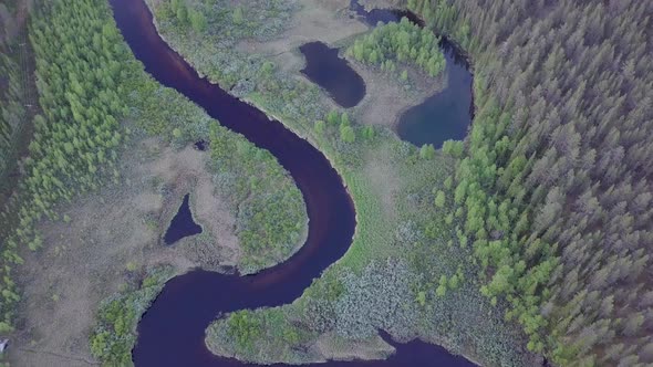 WIlderness river flowing through forest in Lapland Finland filmed from air with a drone.