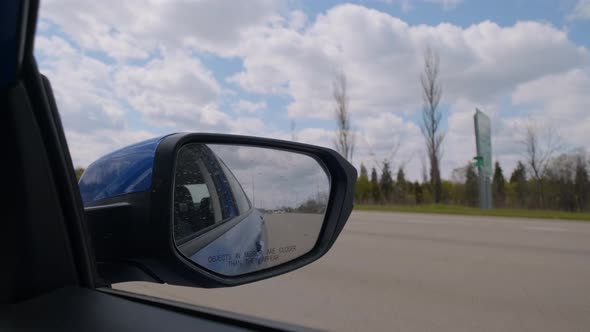 Mirror of a Car Moving on a Highway