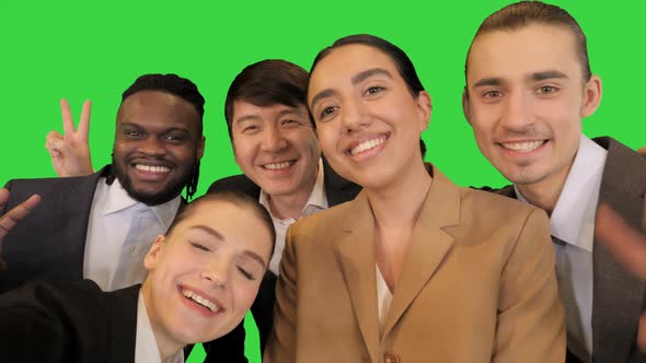 Young Colleagues Make Selfies and Smile on a Green Screen Chroma Key
