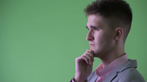 Closeup Profile View of Happy Young Businessman Thinking